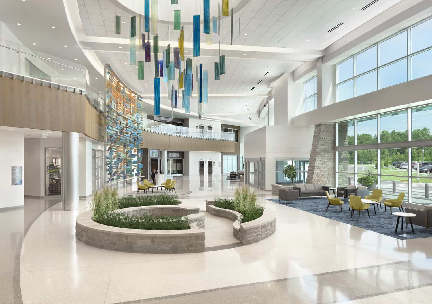 Within a modern lobby, a hanging art installation is suspended over an interior stone garden, symbolizing movement and transformation. This image shows BSA's expertise in interior design.