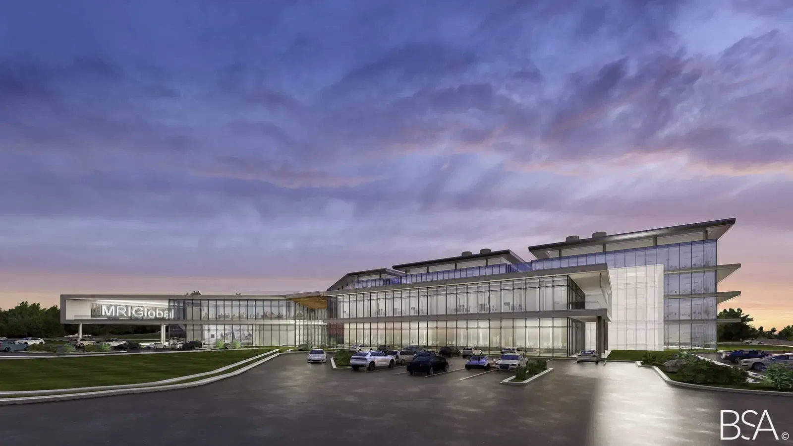 Evening architectural rendering of the MRIGlobal headquarters building designed by BSA architects. The modern structure features extensive glass curtain walls, angular roof lines, and a sleek contemporary design illuminated at dusk. The building prominently displays the