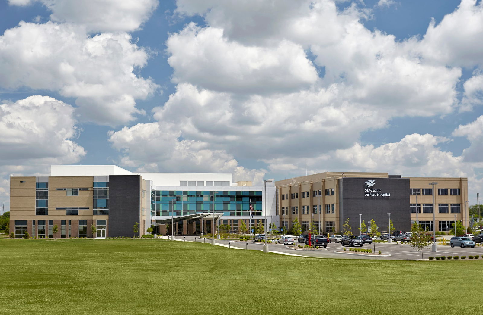 The exterior of Ascension St. Vincent Fishers Hospital with a glass-paneled exterior featuring blue and green tinted windows, as well as brown and tan brick with large windows. This image show's BSA's expertise in exterior architecture.