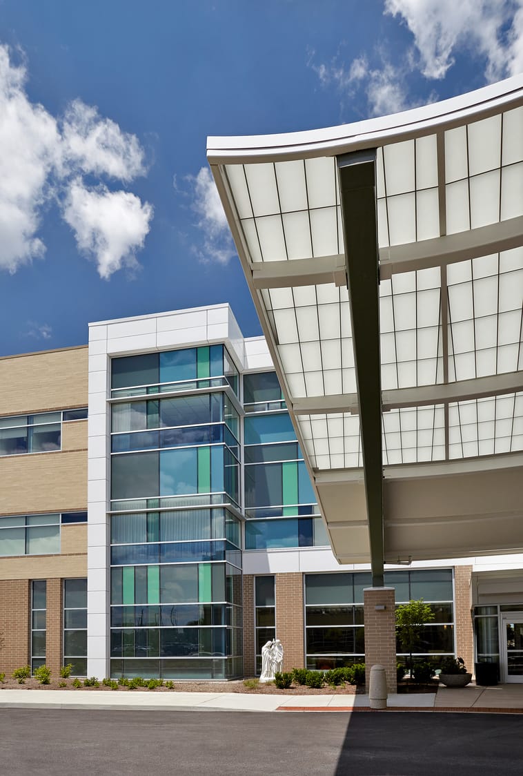 The exterior of Ascension St. Vincent Fishers Hospital with a glass-paneled exterior featuring blue and green tinted windows. This image show's BSA's expertise in exterior architecture.
