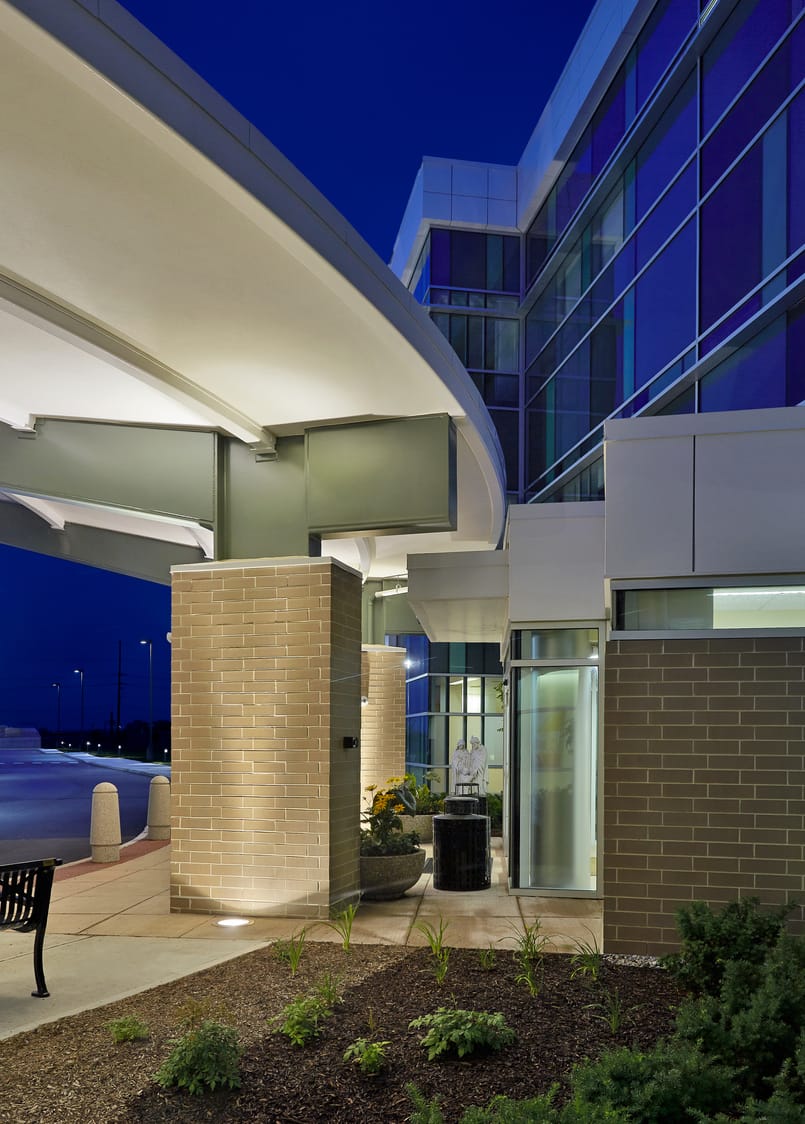 The exterior of Ascension St. Vincent Fishers Hospital with a glass-paneled exterior featuring blue and green tinted windows in dusk. This image show's BSA's expertise in exterior architecture.